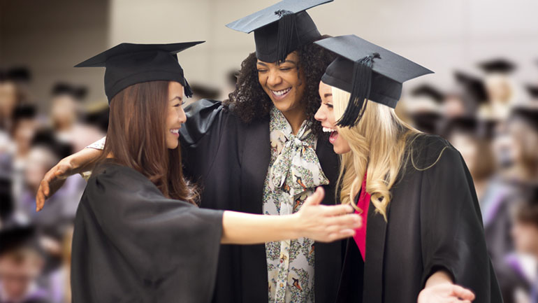 three friends hug at their graduation