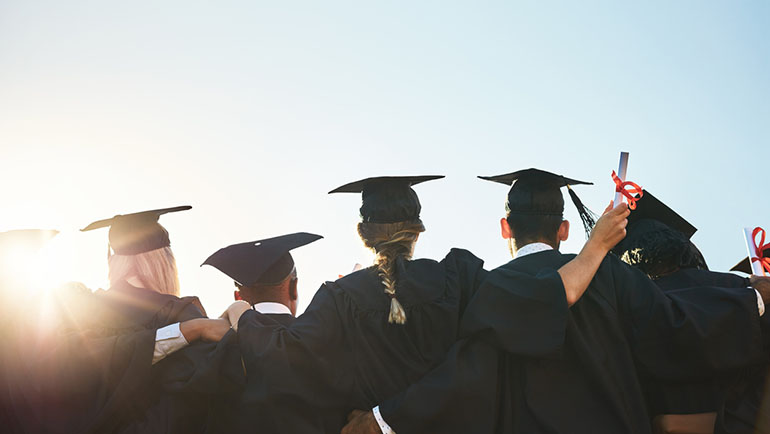 Rearview shot of a group of university students standing outside on graduation day 