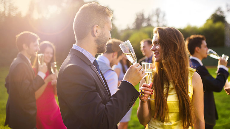 Guests clinking glasses while drinking champagne in the background