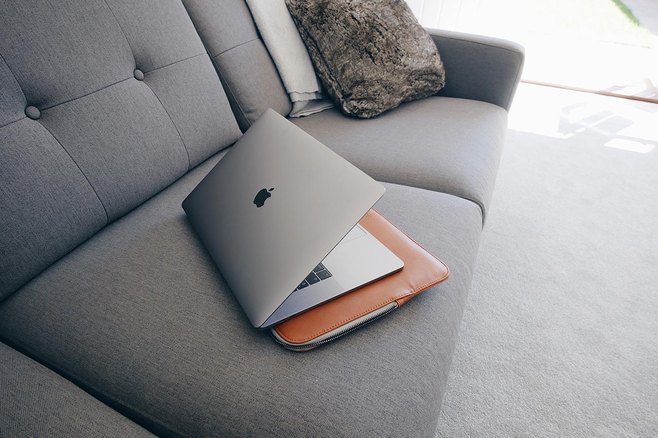 Leather laptop case with laptop on sofa