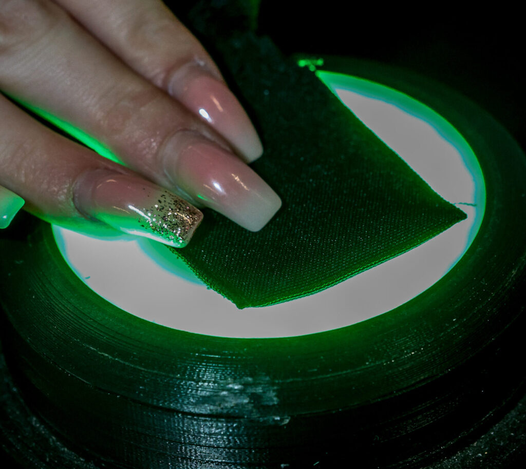 A staff member scans the microchip in a graduation gown onto a reader that has turned green