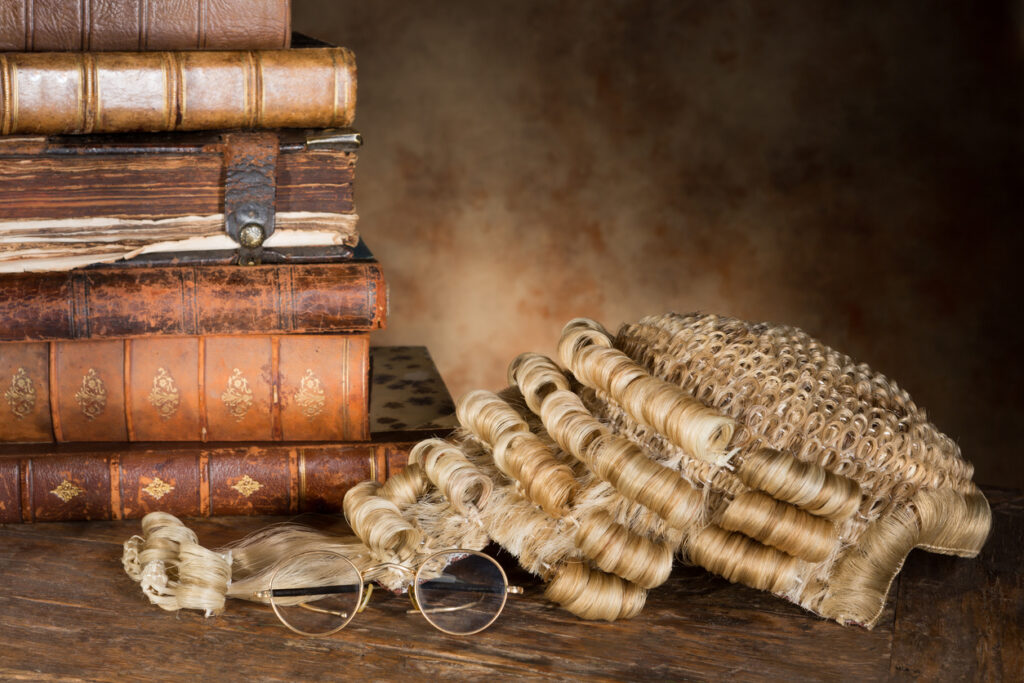 Antique lawyer's wig with old books and glasses