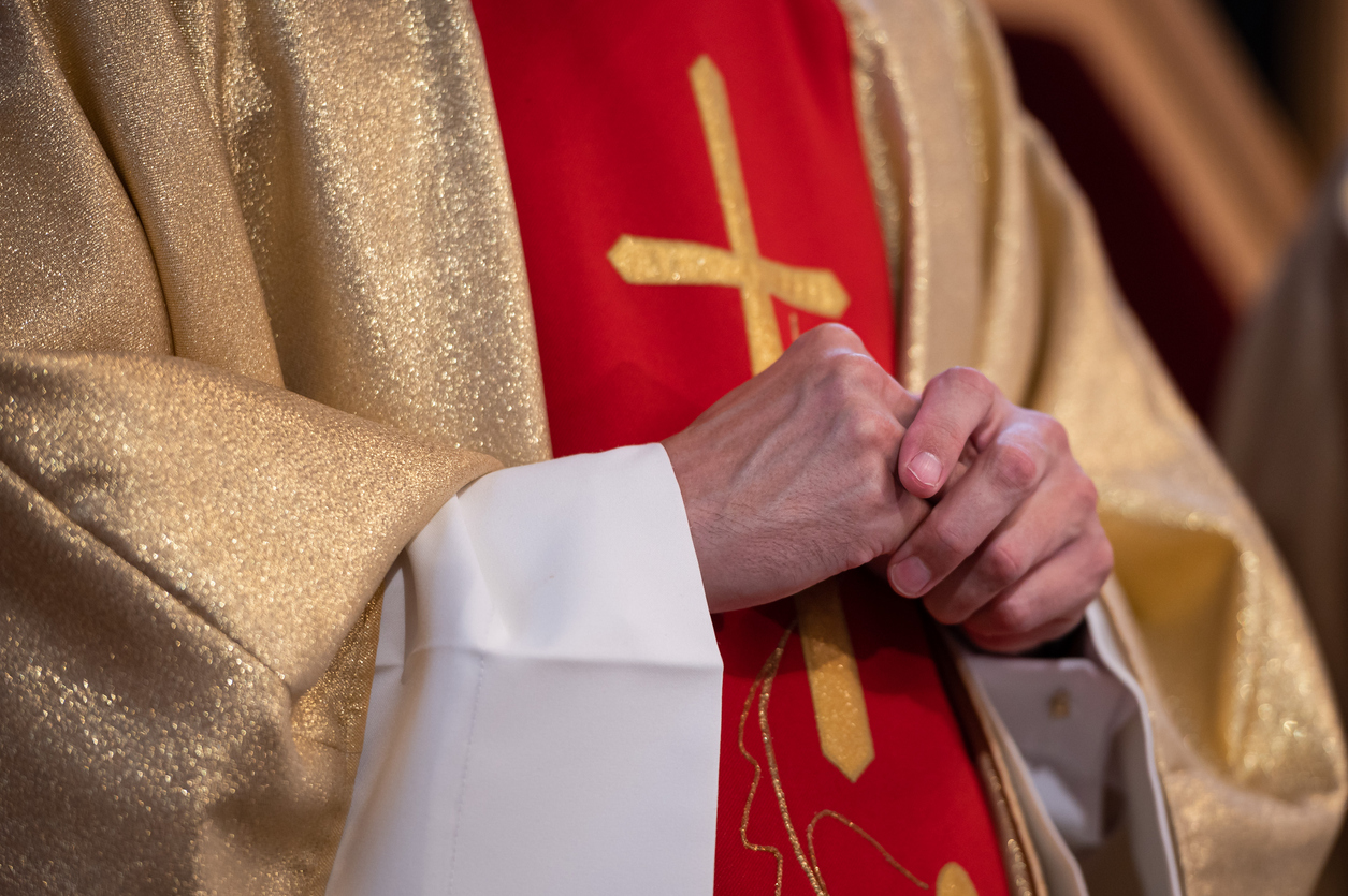 Hands of a Catholic priest in a cassock