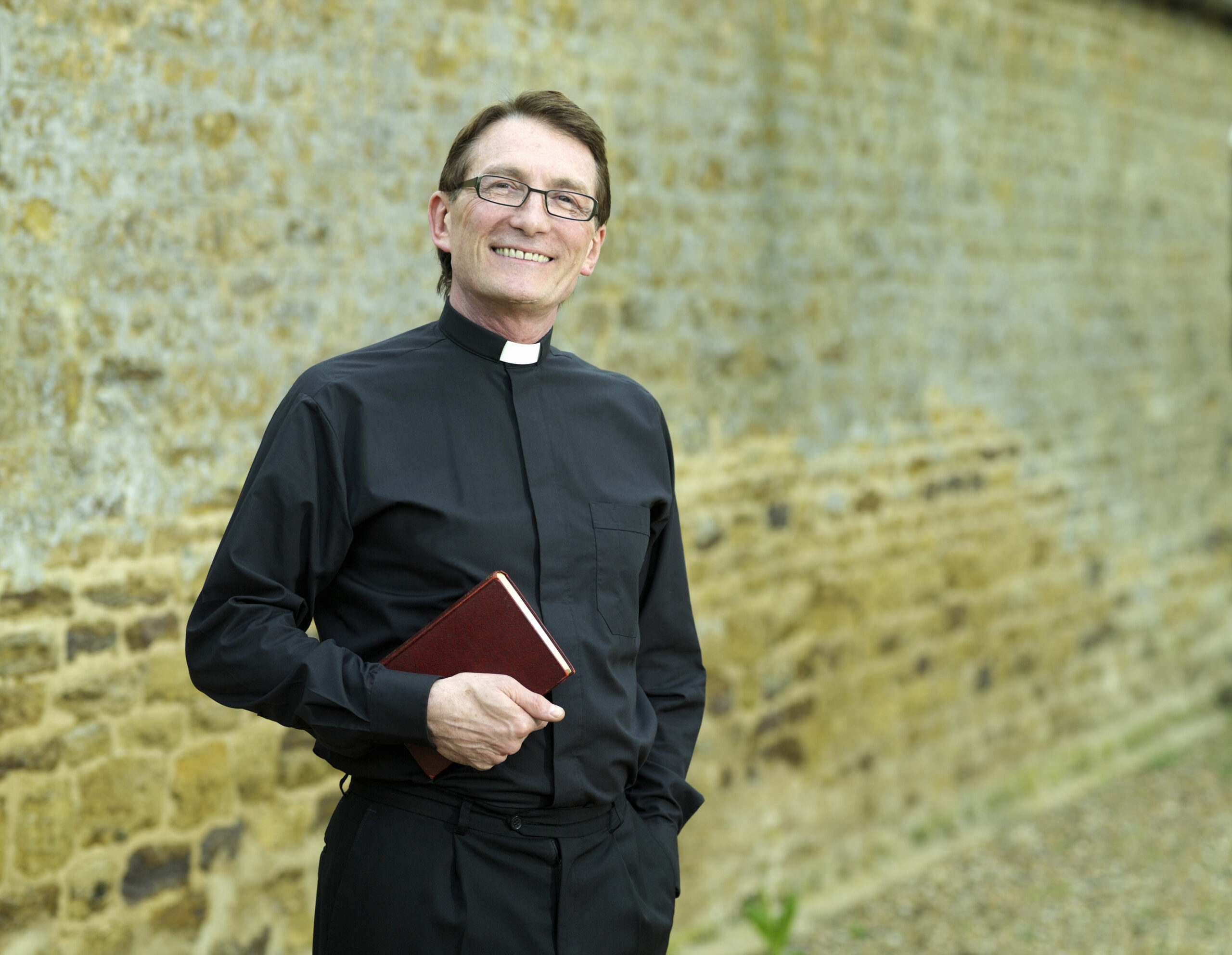 A Priest holding a bible image